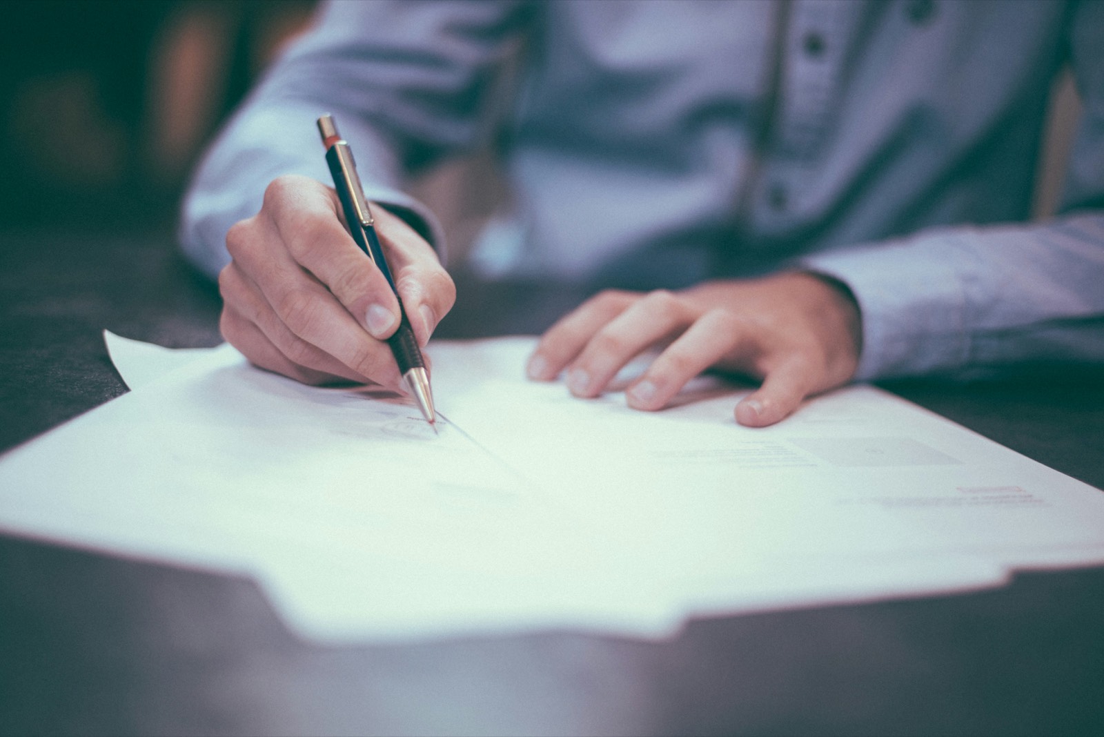 A person reviewing and signing paperwork